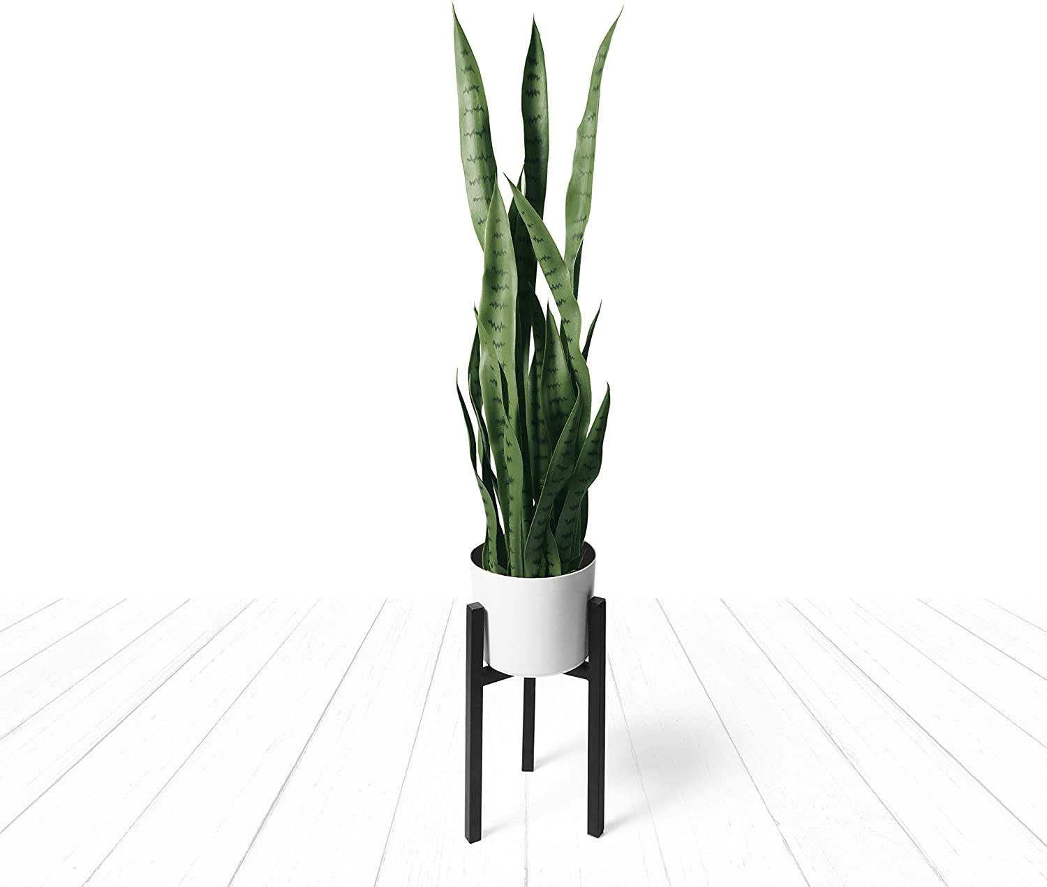 faux snake plant in white pot on modern black plant stand