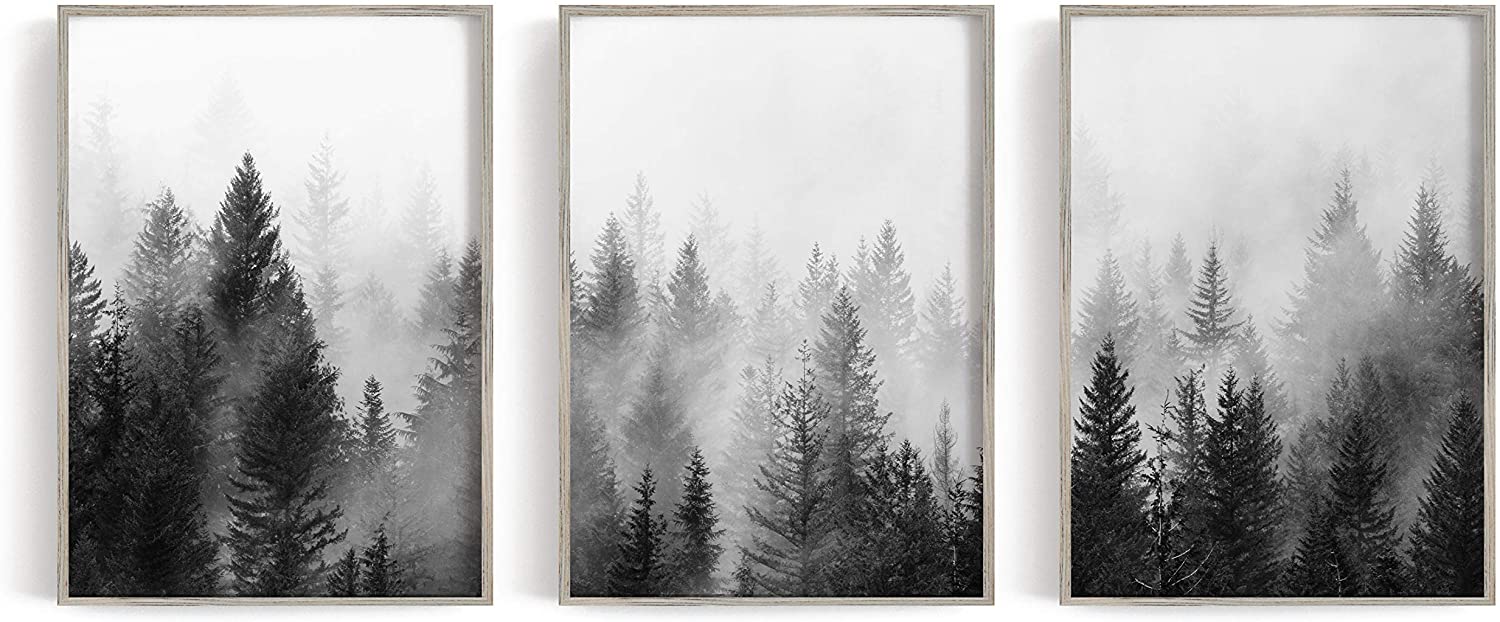 three large wall art canvases with black and grey trees and white fog