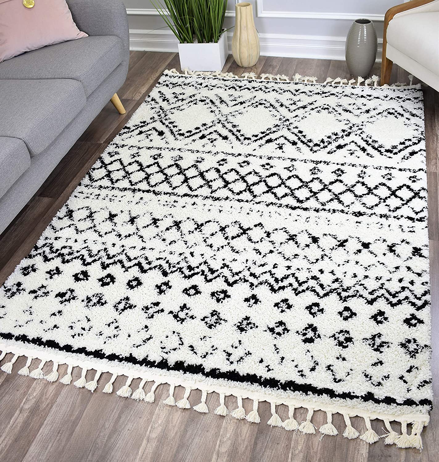 black and white fluffy area rug with geometric designs and tassels